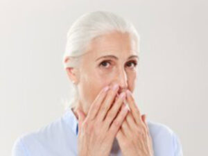 older woman covering mouth